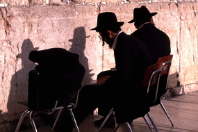 嘆きの壁に向かうユダヤ人。なぜかイスに座っている。