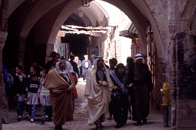 アラブの民族衣装で旧市街を歩く人たち。