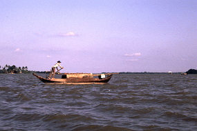 土で濁っただだっ広いメコン川を、手漕ぎの船が一生懸命渡る。